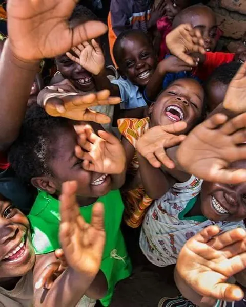 Children laughing and waving at the camera